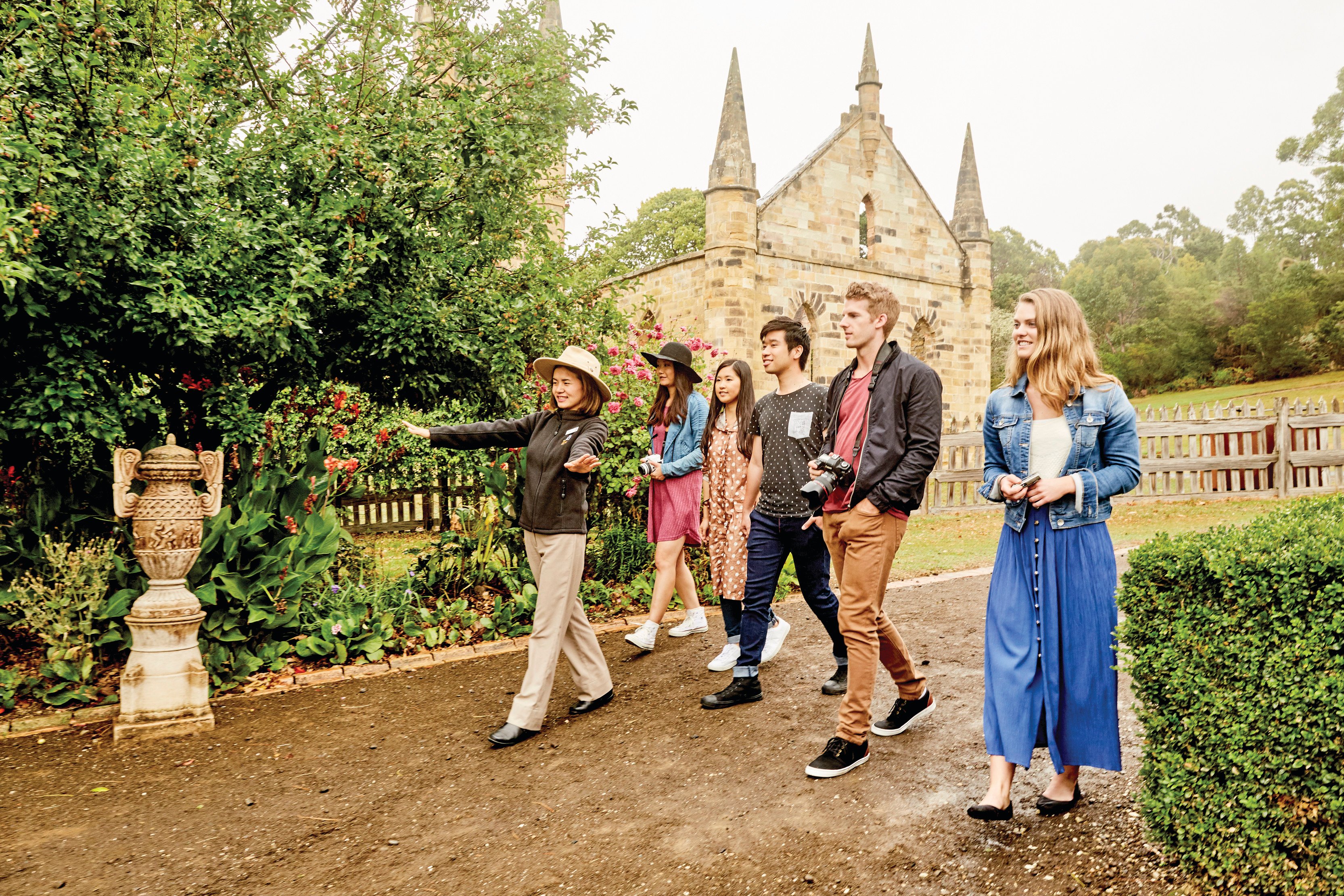 A small group walk through Port Arthur Historic Site with a tour guide.