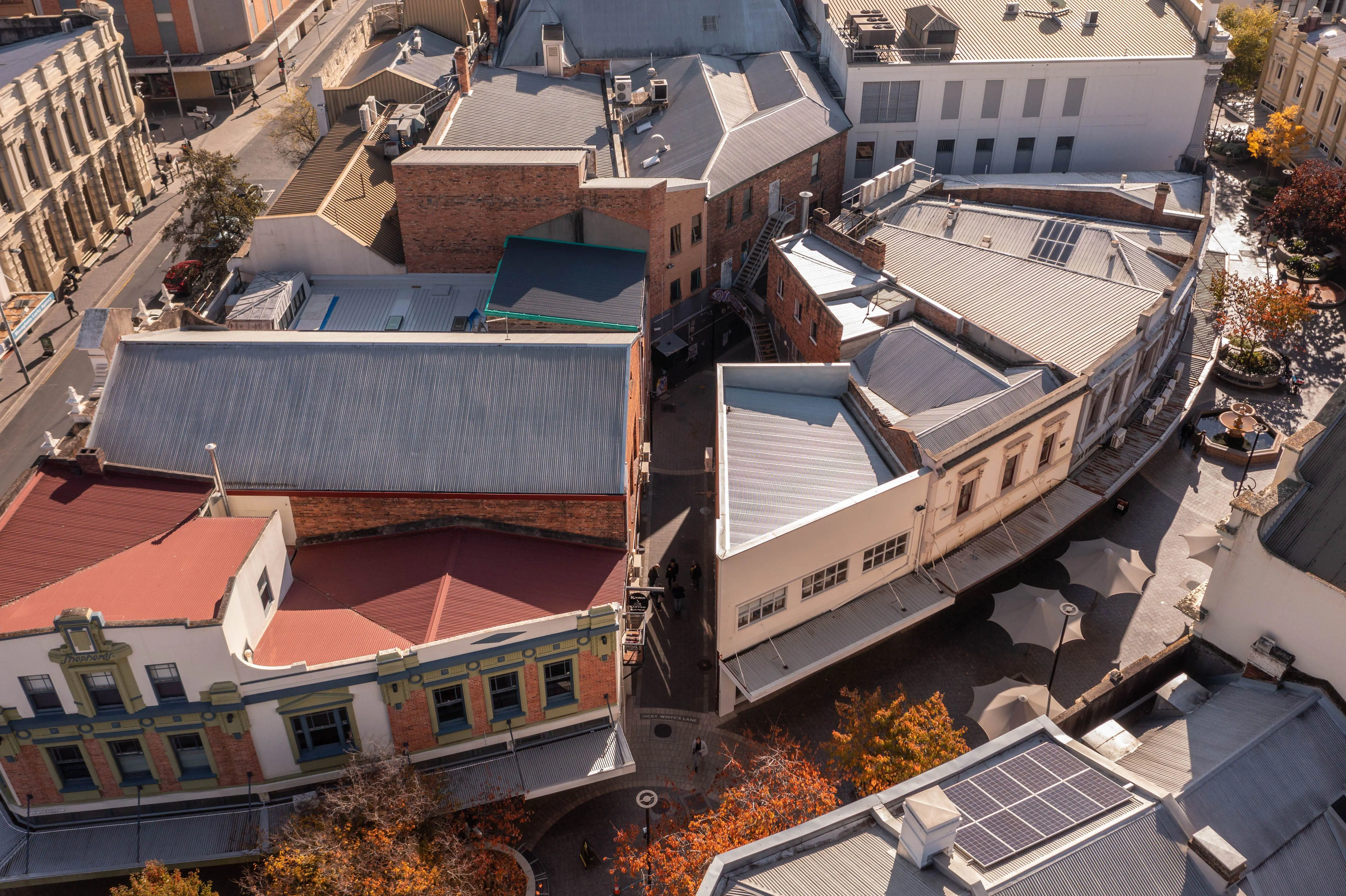 An aerial photograph of a curved pedestrian mall with two-story buildings either side.