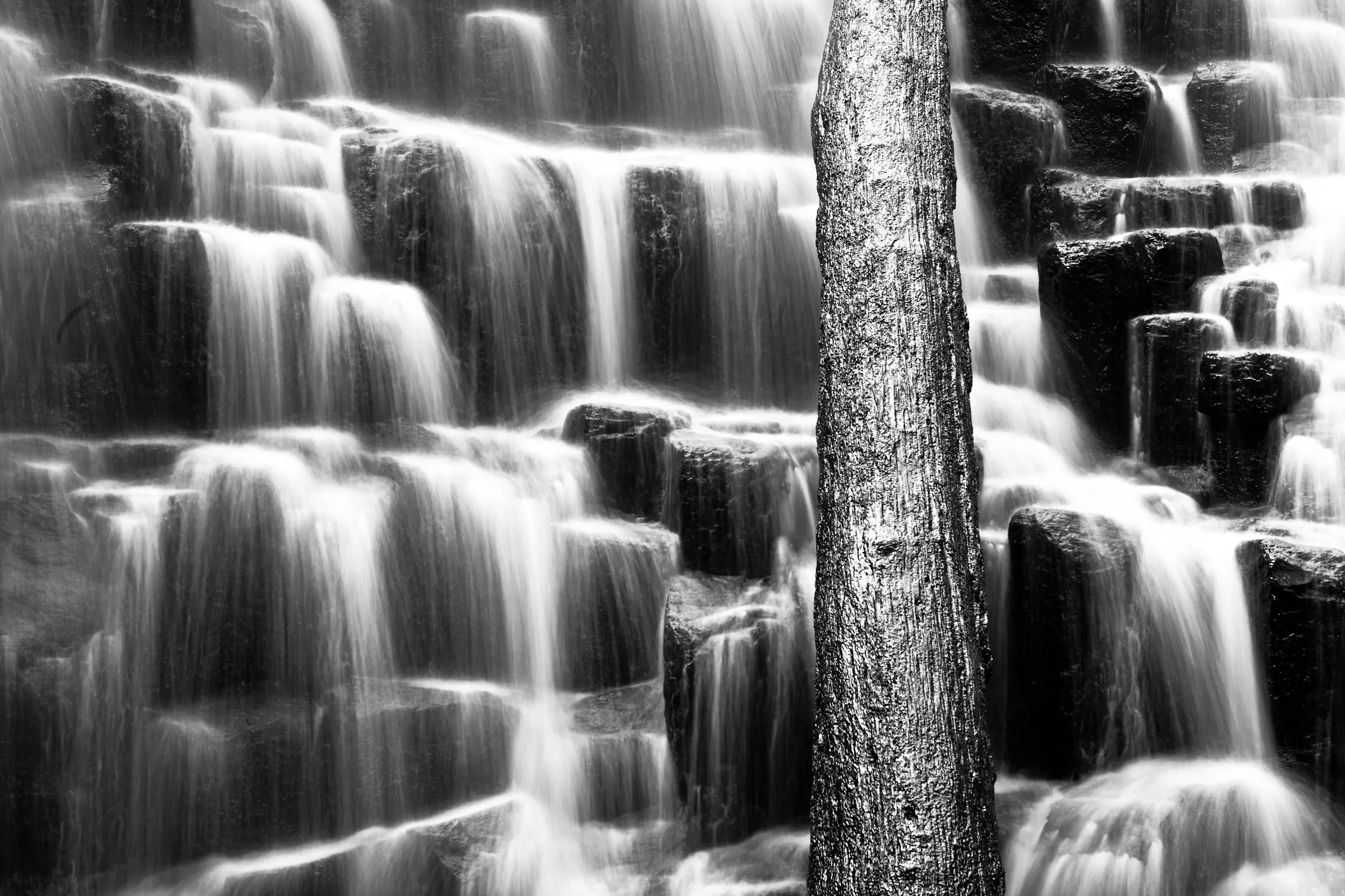 Water spills over rocks that form the shape of stairs at Dip Falls.