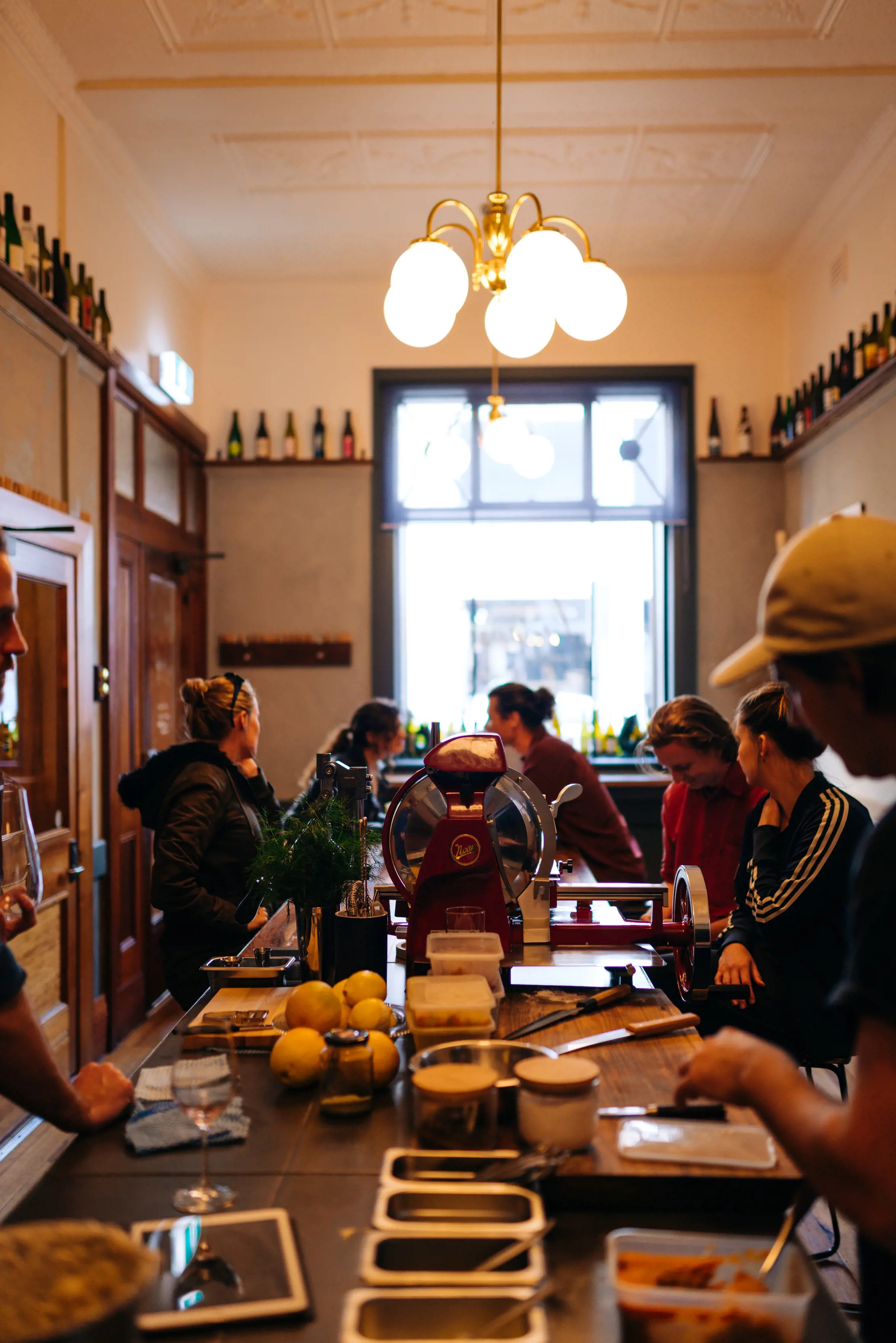 A group of people enjoying food and wine inside the rustic Lucinda - Bar and Food.