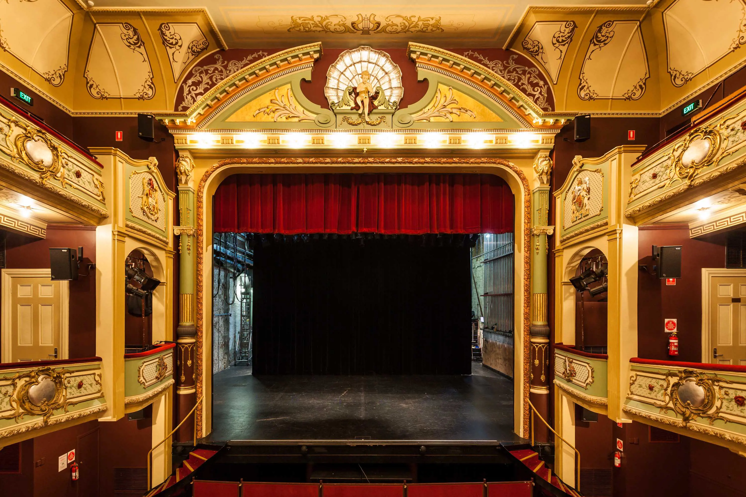 A stage with red velvet curtains and ornate decorations.