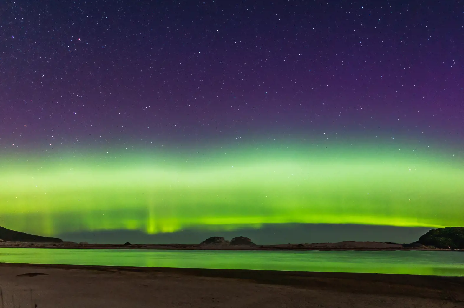 Coulourful aurora over a coastline, Tasmania