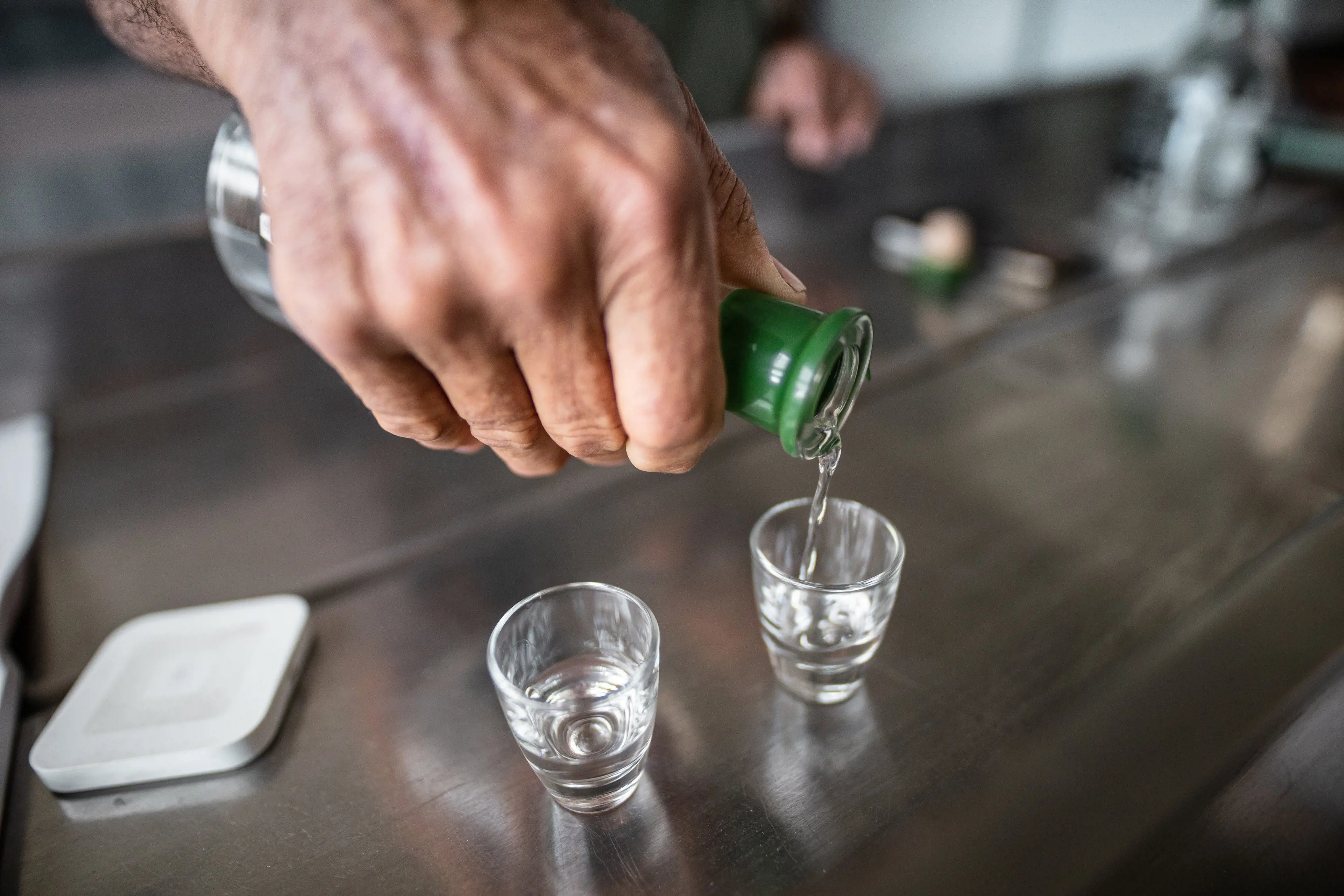 Clear spirits being poured into a shot glass at Bakehouse Distillery, Dover.