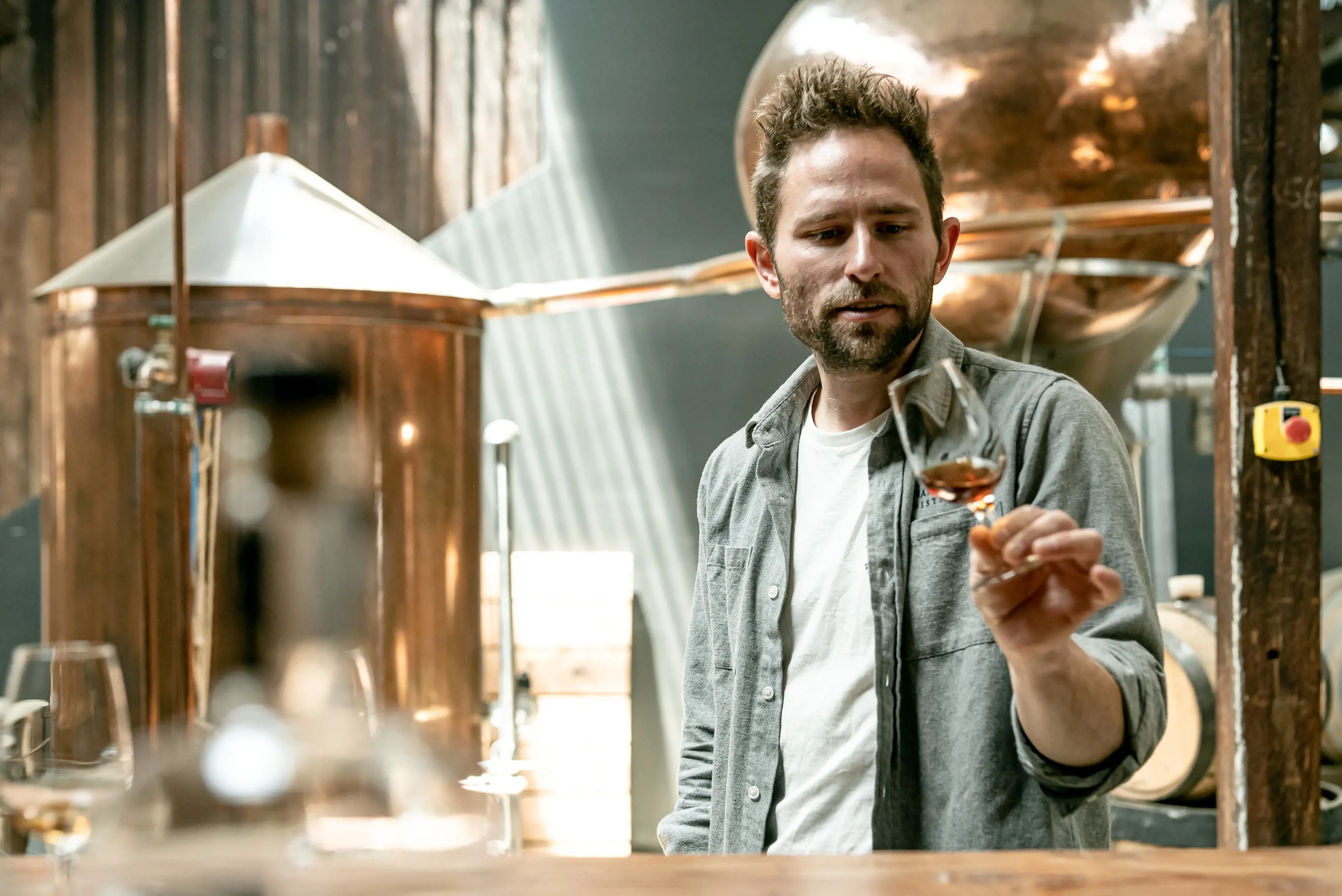 Mansampling Fine Apple Brandy in the Charles Oates Distillery, Located in Willie Smith's Apple Shed.