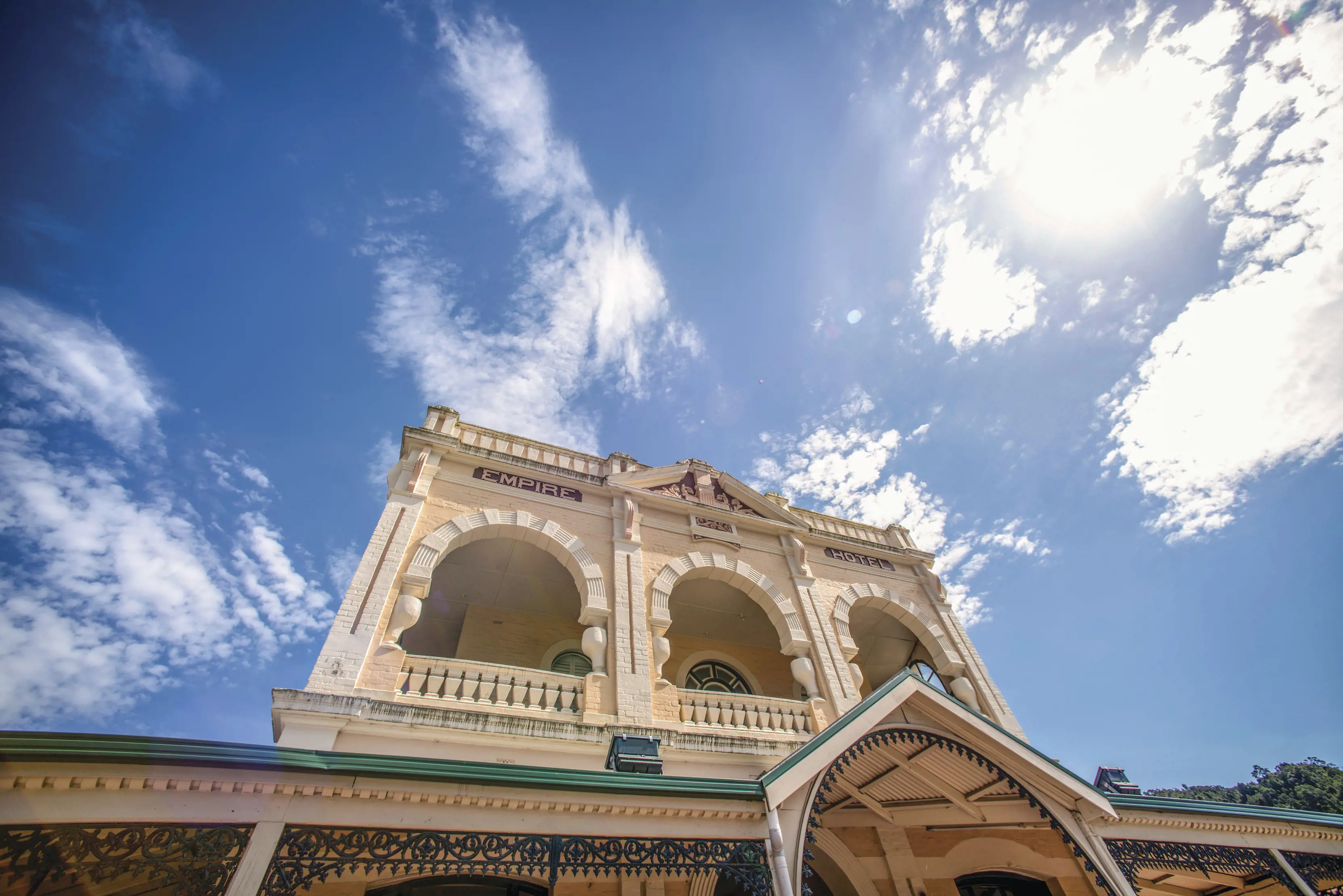 Exterior shot from below looking up at the Empire Hotel, Queenstown. Blue skies in the background.