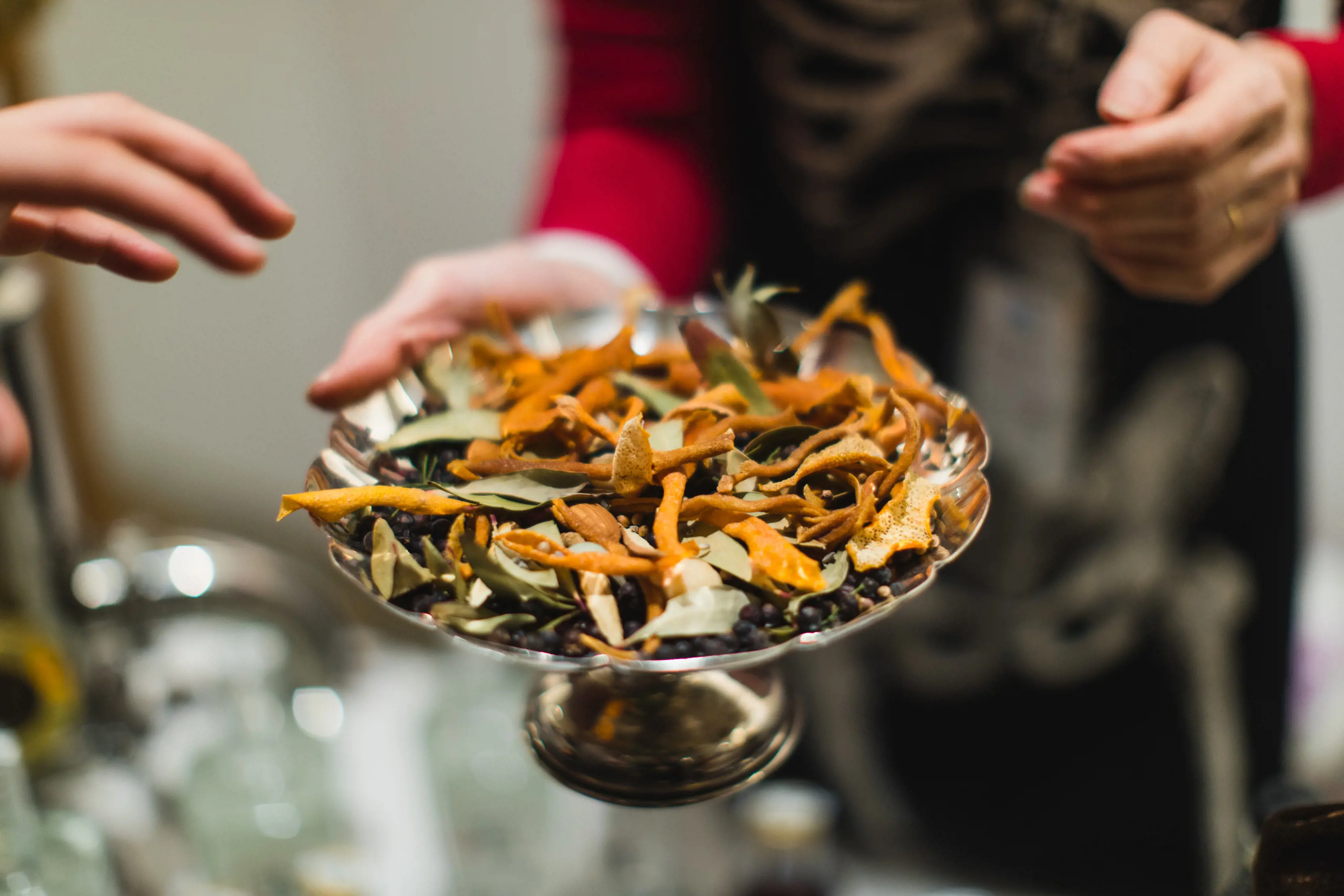 Close up of gin botanicals in a silver dish.