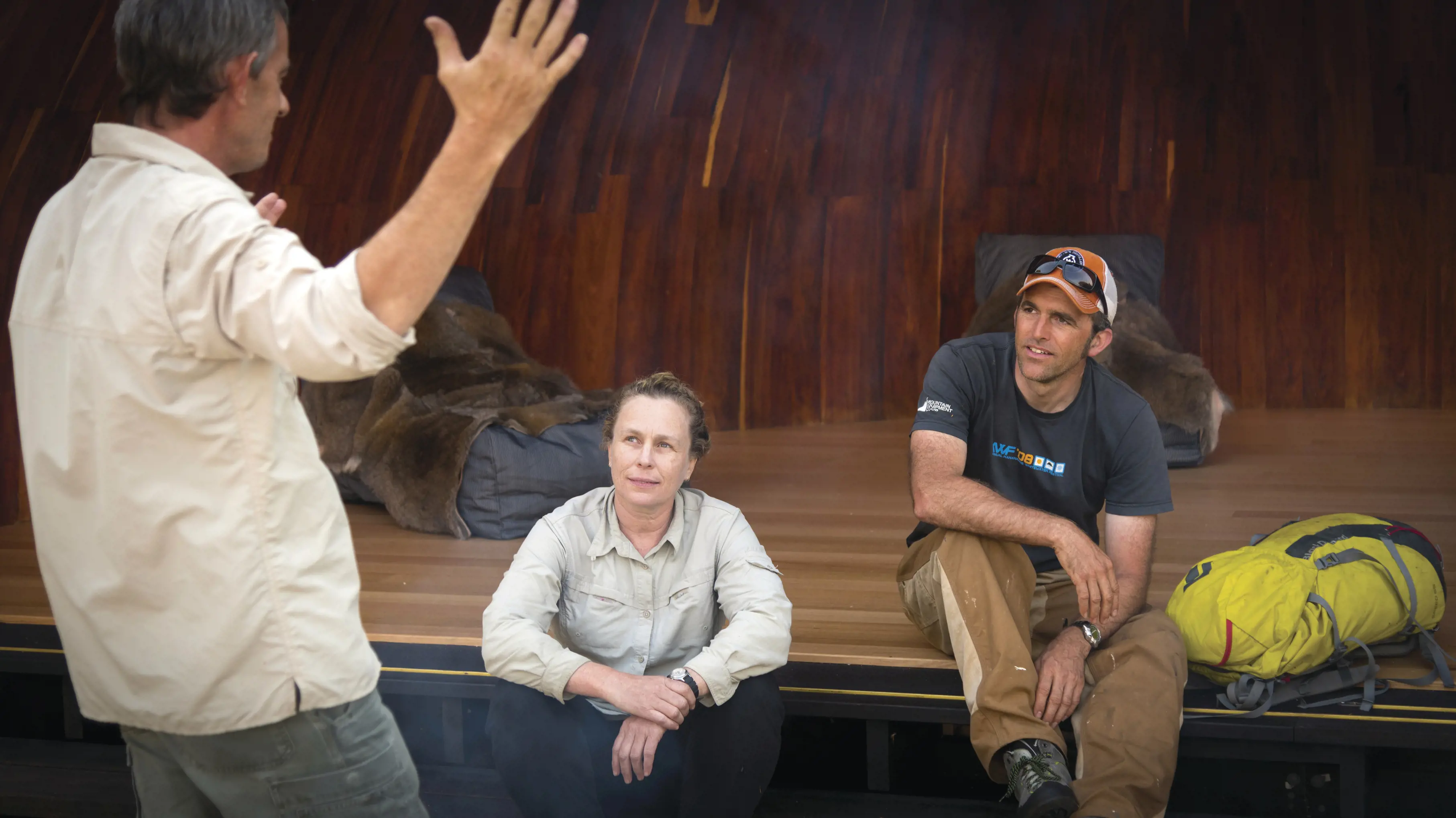 A tour guide speaks to hikers people whilst sat outside the wukalina Walk camping accomodation