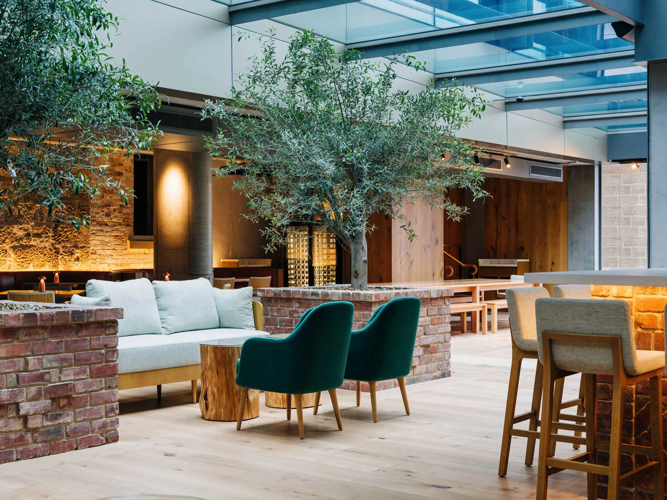 Outdoor tables in a sheltered courtyard outside a restaurant with wooden interiors.