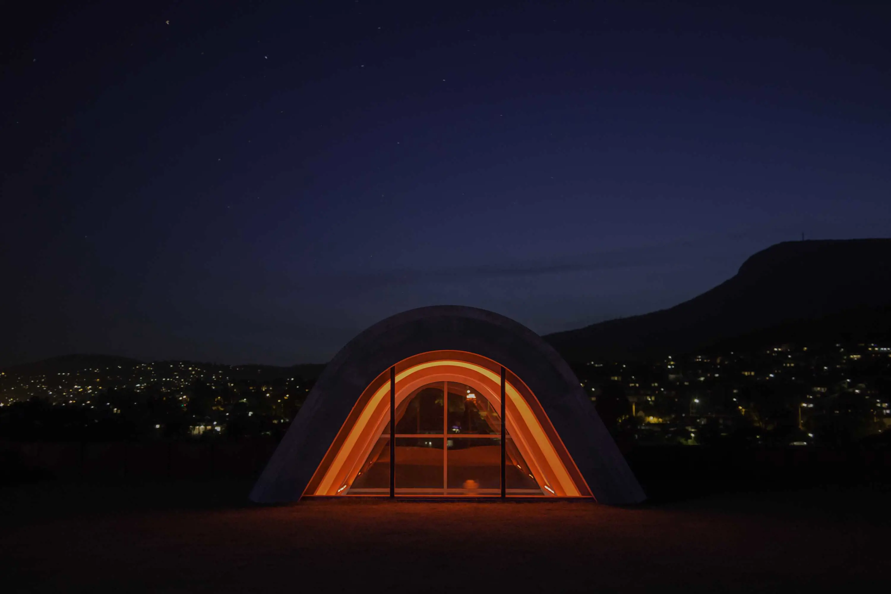 A triangular-shaped architectural window, illuminated with red lighting.