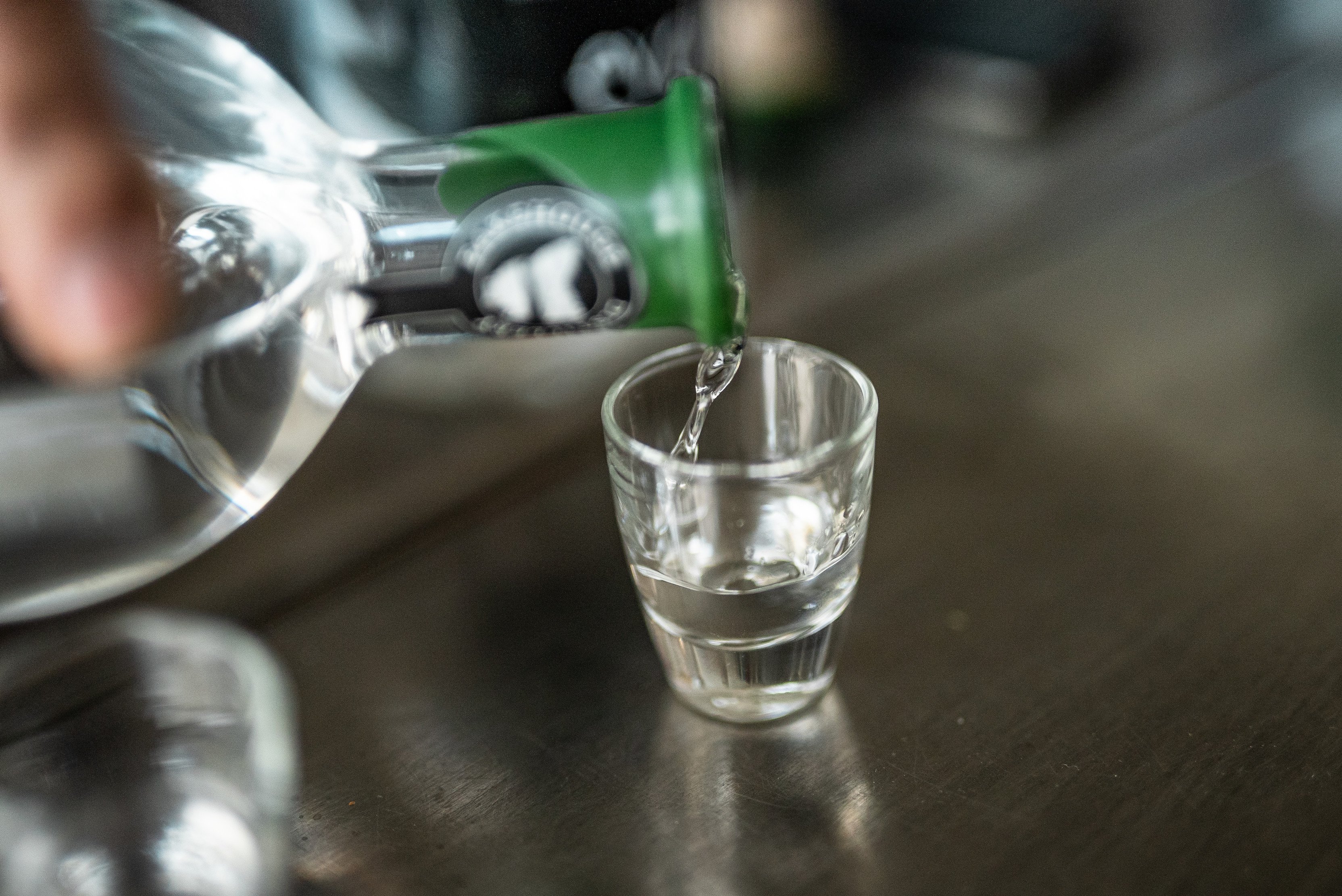 Clear spirits being poured into a shot glass at Bakehouse Distillery, Dover.