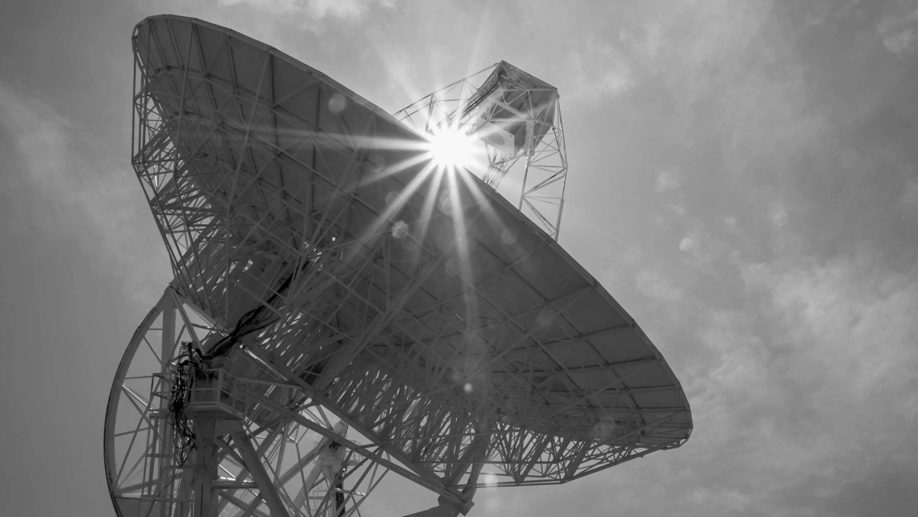 An enormous, white sattelite dish points towards the sky.