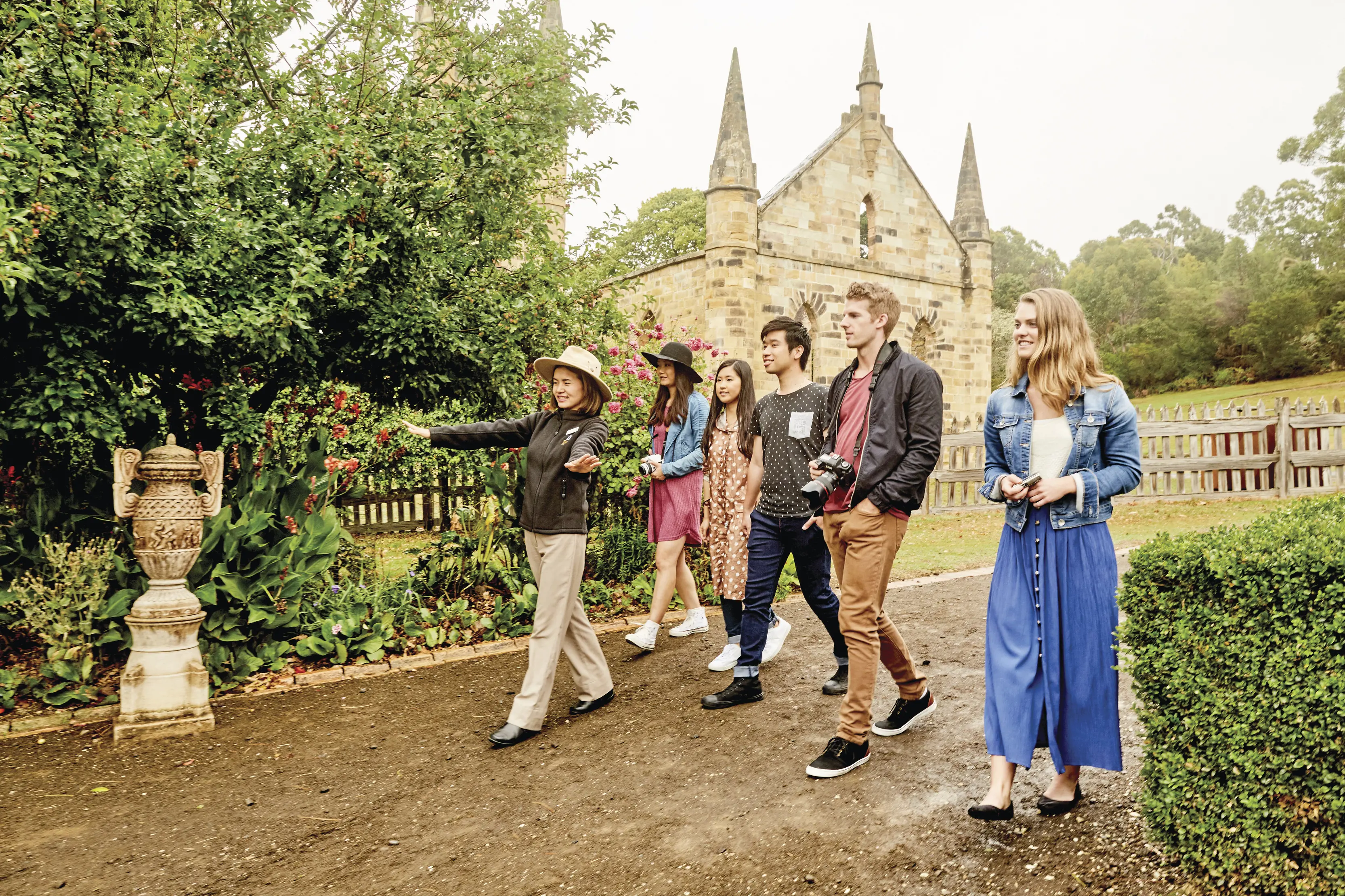 A small group walk through Port Arthur Historic Site with a tour guide.