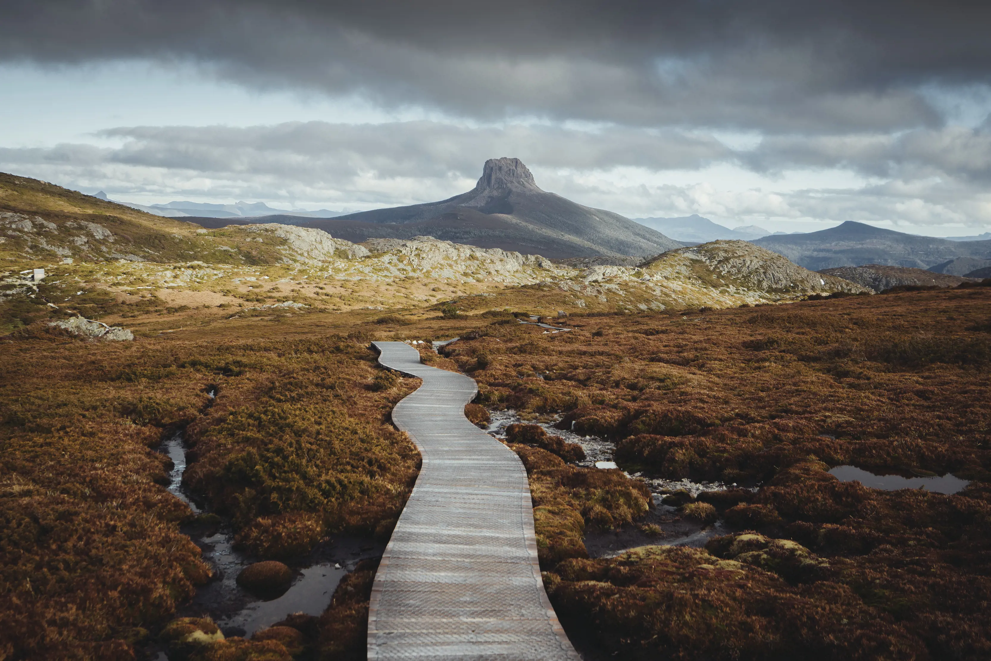 Landscape of the Overland Track, with Barn Bluff in the backdrop. The leaves are orange Autumn coloured.