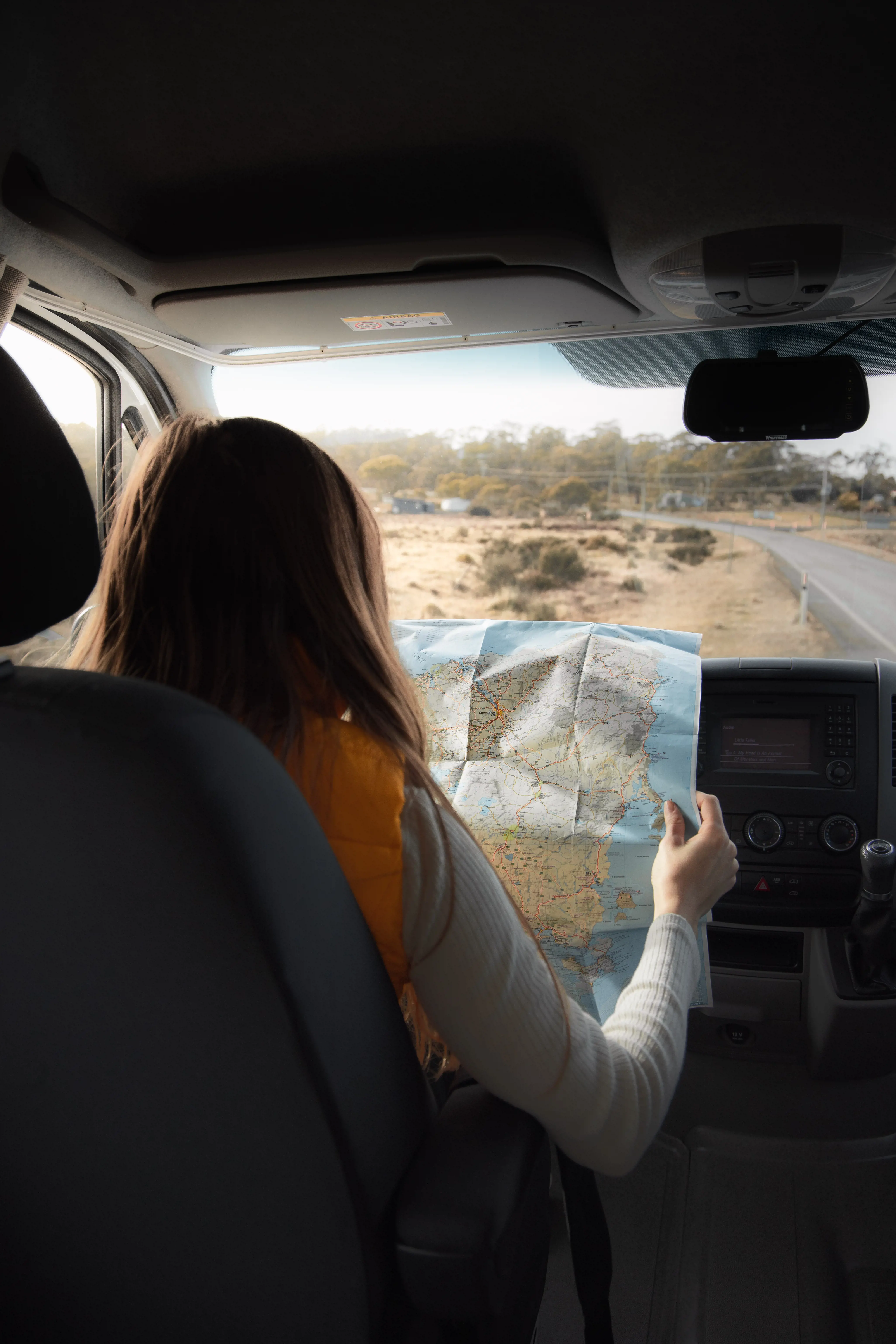 The front car passenger looks at the map whilst touring Bruny Island.