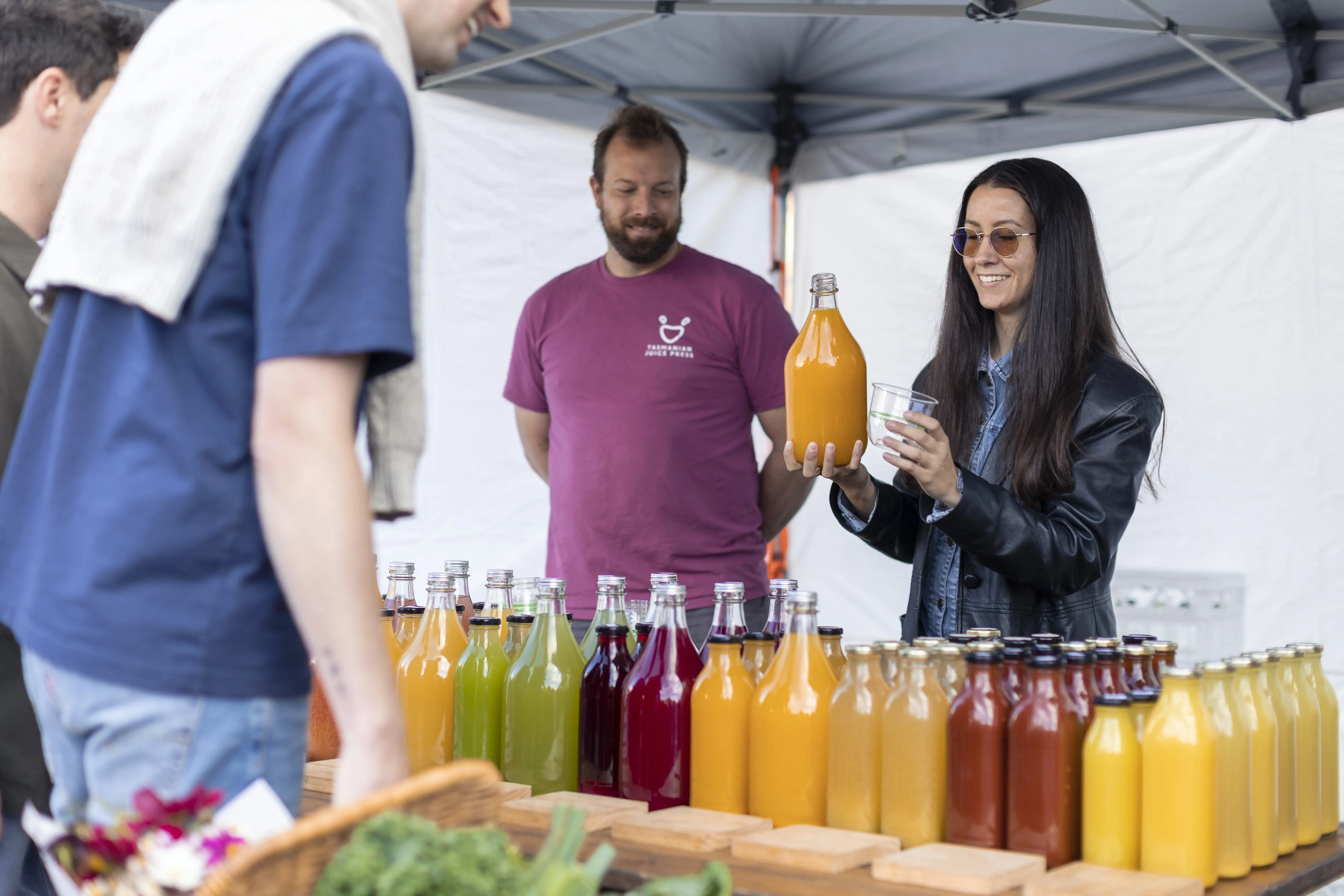 Two customers buy juice from fresh juice stall. 