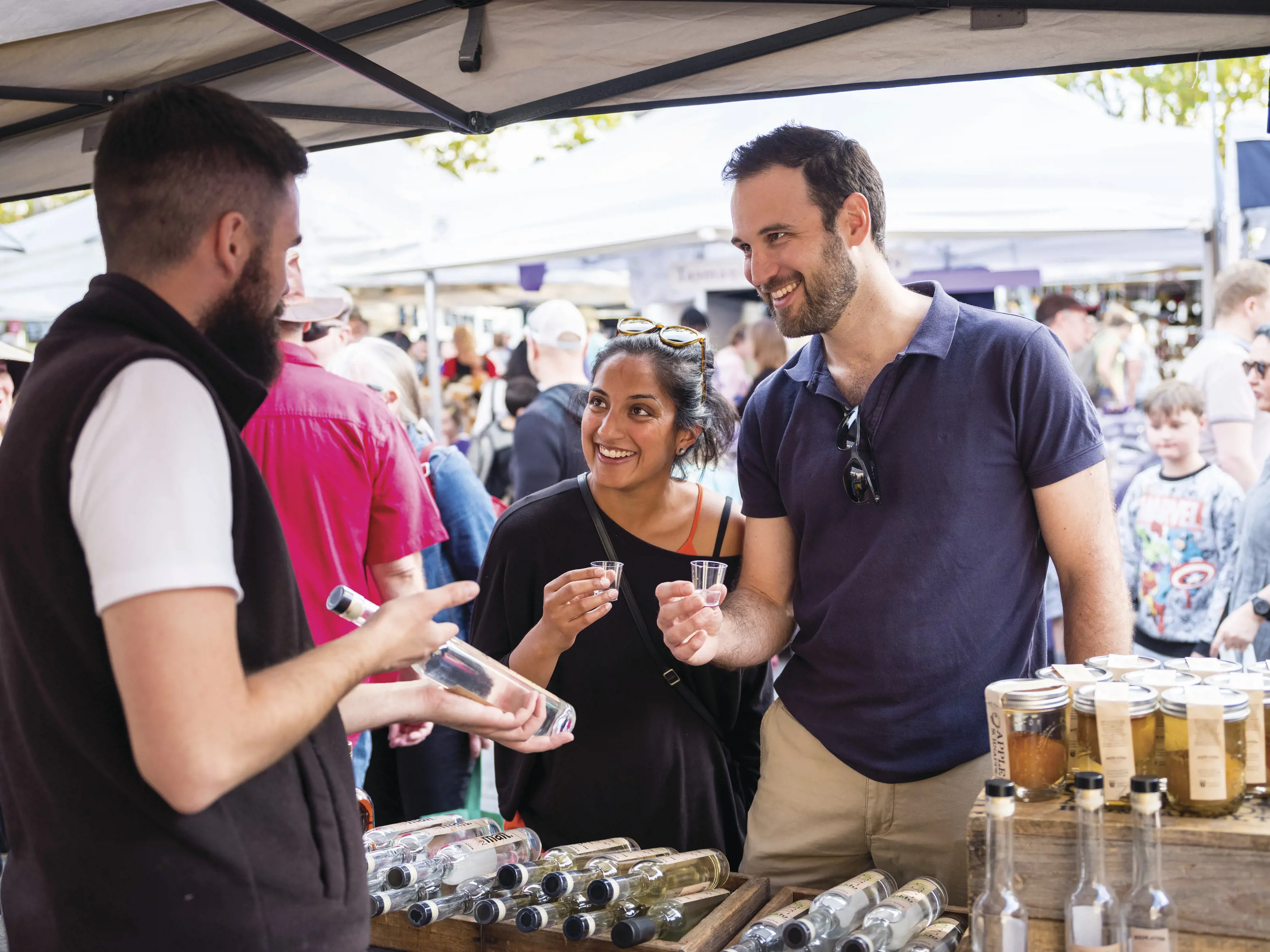 Couple purchasing produce at Salamanca Market. The market is set among historic Georgian sandstone buildings at Salamanca Place, Hobart.