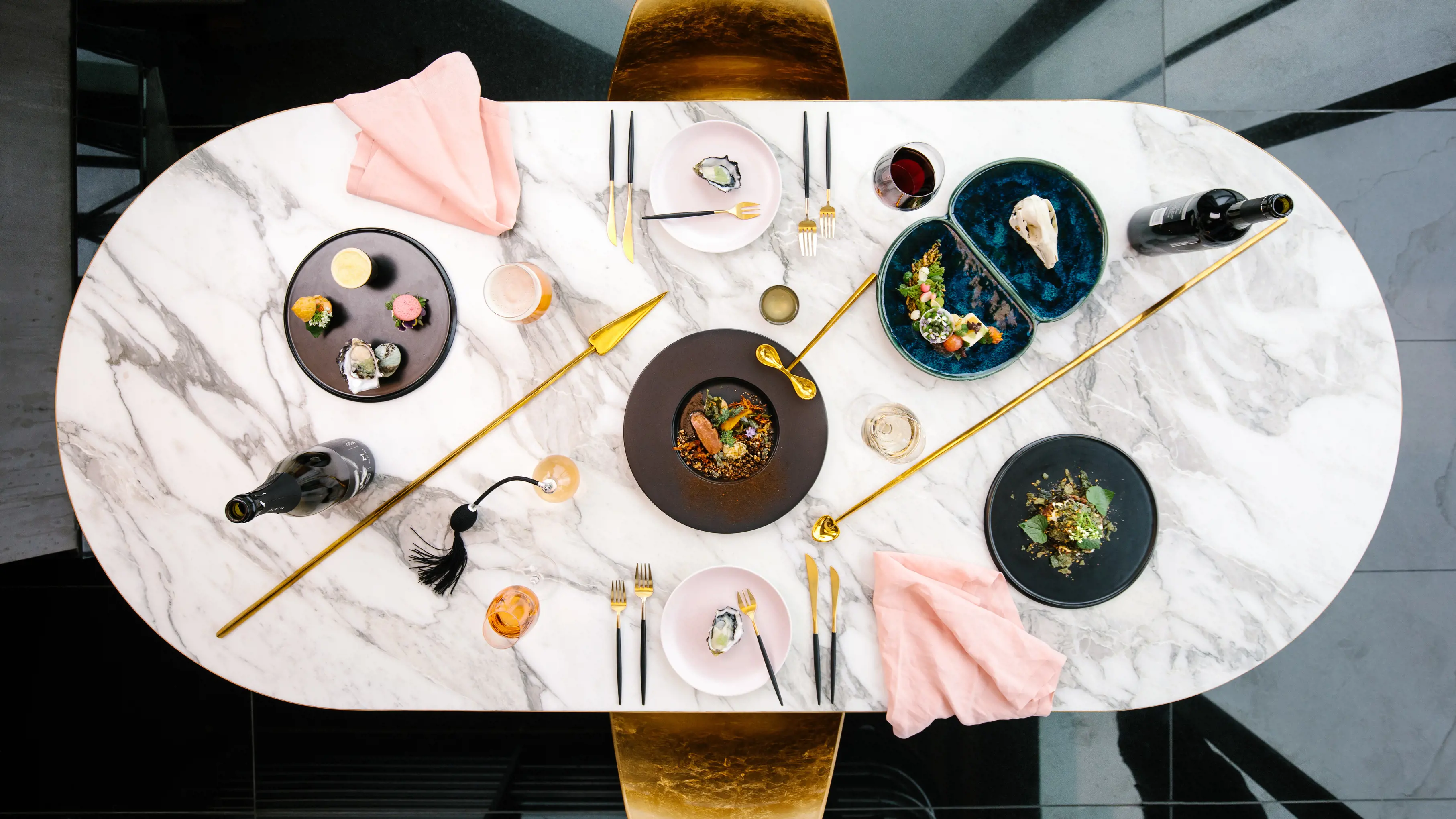 Aerial table shot of food on a marble table at Faro Lunch and Experiments, a bar and restaurant at Mona.