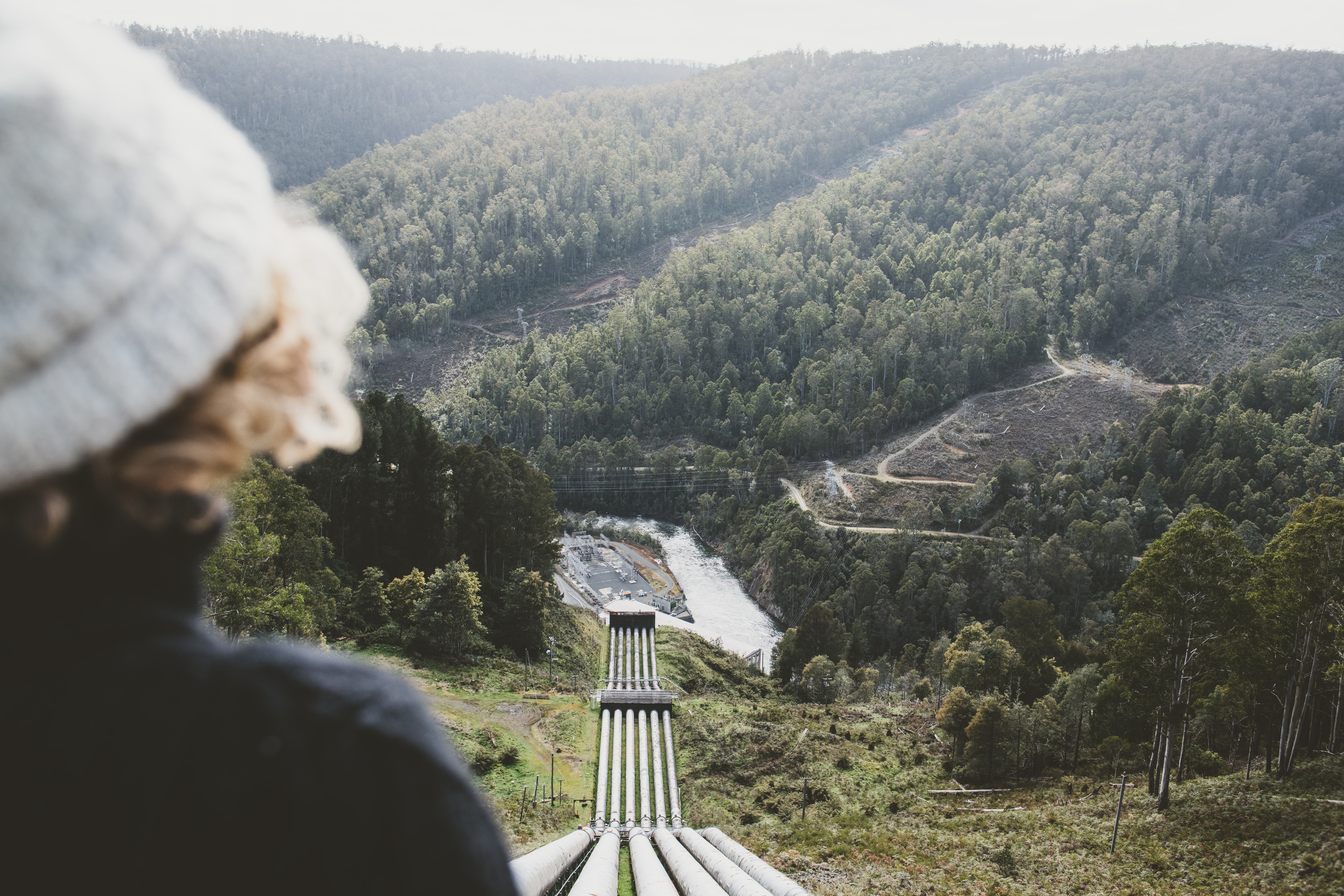 Image of a person in the foreground overlooking the penstocks feeding the Tarraleah Power Station, a hydroelectric power station located in the Central Highlands.